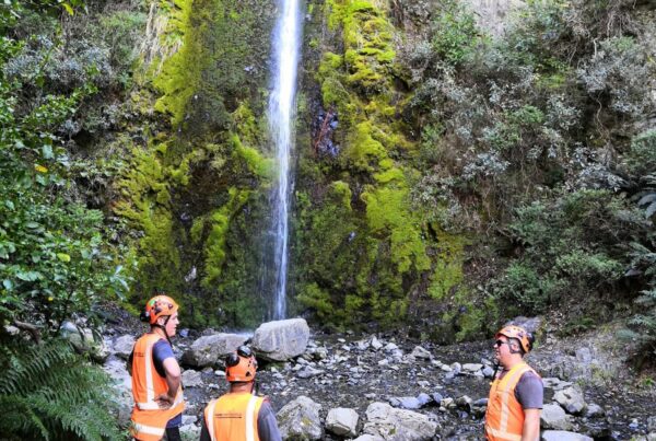 Civil contractors standing near a waterfall during walking track construction and recreation construction works in a rocky natural reserve. The image highlights park construction, site preparation, erosion control and project management for improved public access through the Hanmer waterfall track.