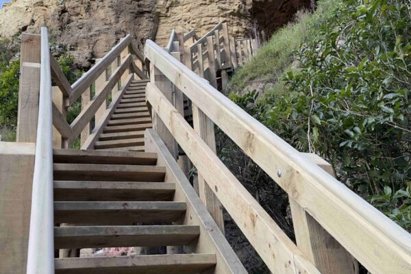 Completed timber staircase and handrail built against a rocky hillside at Barnett Park, improving walking track access through steep terrain. The image highlights recreation construction, timber structures, park construction, walking track construction and civil construction by civil contractors.