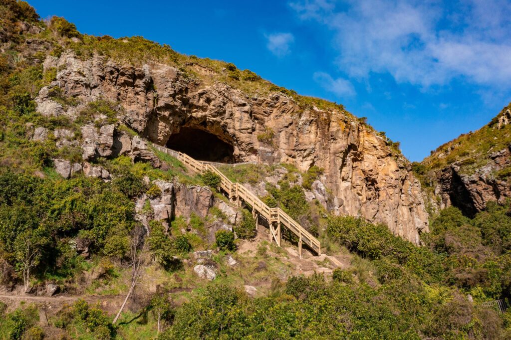 Completed timber staircase and walkway leading to a cave at Barnett Park, providing improved access through a steep rocky reserve. This image shows civil construction, walking track construction, recreation construction, timber structures and park construction by civil contractors.