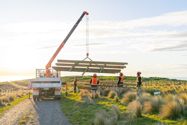 Crane truck lifting timber beams during walking track construction and staircase replacement works at Barnett Park. This image shows civil contractors managing sling operations, timber structures, park construction and recreation construction on a remote hillside site.