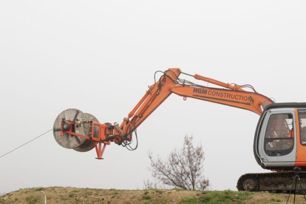 Excavator-mounted construction drill working on a hillside for civil construction, drilling services and adventure infrastructure works. The image shows civil contractors completing rock anchors, soil nails, slope retention and ground stabilisation for a complex park construction project.