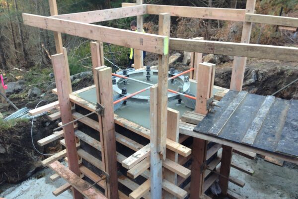 Timber formwork and concrete structure preparation underway for adventure infrastructure in a forested park construction site. The image shows civil contractors managing foundation construction, siteworks and structure construction for a complex recreation construction project.