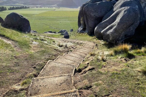 Walking track construction with timber edging and compacted surface on a hillside at Kura Tawhiti Castle Hill, overlooking the surrounding valley. This image shows civil contractors completing recreation construction, park construction, erosion control, site preparation and siteworks.
