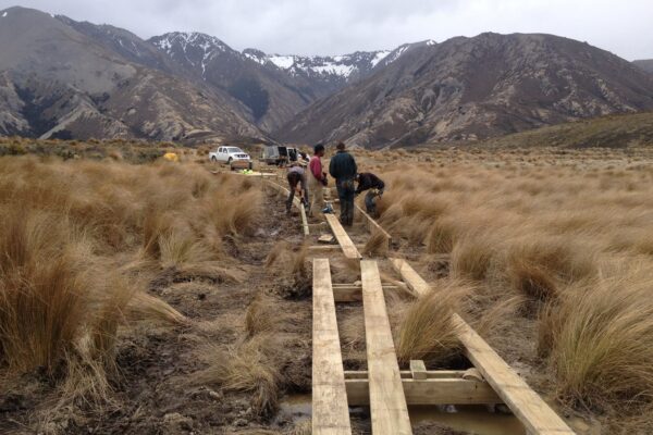 Timber structures being assembled across wet ground during walking track construction in a rural reserve. This image shows civil contractors delivering recreation construction, park construction, siteworks and erosion control for improved access through natural terrain.