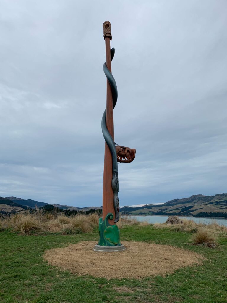 Completed pou installation on Quail Island overlooking the harbour, showing a finished cultural structure within a coastal recreation setting. The image highlights civil construction, structure construction, foundation construction, park construction and project management by civil contractors.