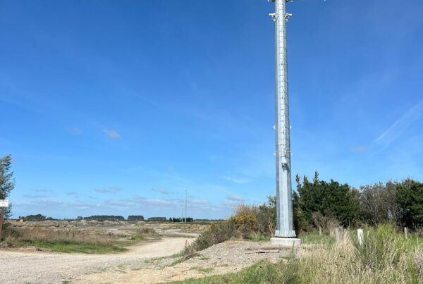 Completed pole installation for power infrastructure and transmission line construction in a rural landscape. The image shows overhead infrastructure, tower installation, civil construction and utility infrastructure delivered by civil contractors.