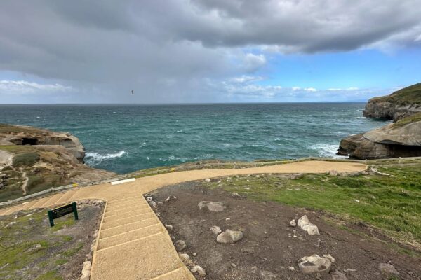 Coastal walking track construction leading to a lookout area above the sea, with formed pathways and natural rock features. The project shows recreation construction, erosion control, civil construction and site preparation for improved access through coastal terrain.